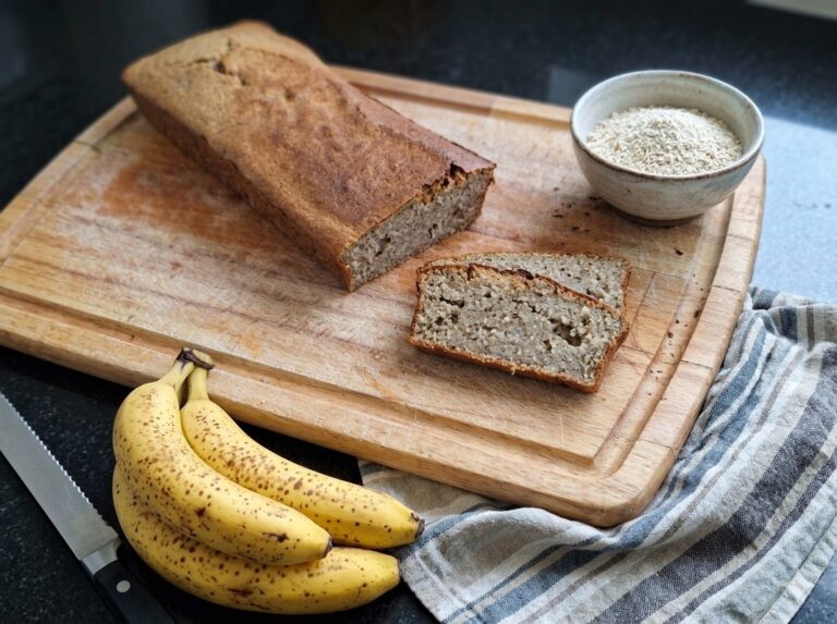 fertiges, angeschnittenens Bananenbrot ohne Zucker auf einem Holzbrett